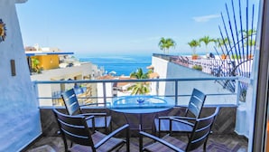 A balcony with a table and chairs, overlooking a coastal view with buildings and palm trees. - Boana Torre Malibu #405 , Ocean view, romantic zone (Amapas)