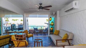 A room with a sofa, chairs, a table, and a view of the ocean. - Boana Torre Malibu #405 , Ocean view, romantic zone (Amapas)