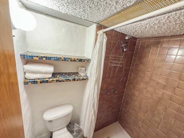 A bathroom with a toilet, a shower, and a shelf with towels. - Boana Torre Malibu #402 , Ocean view, romantic zone (Amapas)