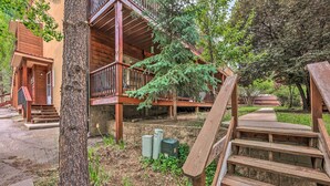 Une cabane en bois avec un balcon, une borne d’incendie et un escalier en bois.