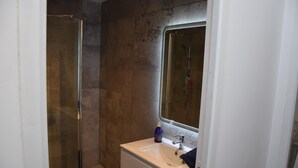 A bathroom with a glass shower enclosure, a white sink, and a mirror above it. - The edge of Saint Quentin 10 minutes from METZ at the foot of Mont Saint Quentin (Lessy)