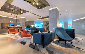 A modern lobby with seating areas, a reception desk, and a large digital screen. - Holiday Inn Express Shenzhen Dongmen by IHG (Shenzhen)