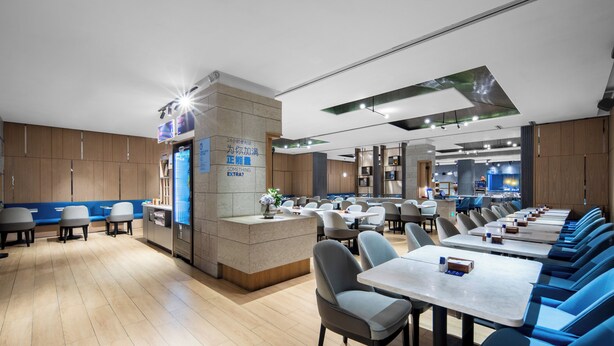 A modern restaurant with a central counter, multiple seating areas, and a clean, contemporary design. - Holiday Inn Express Shenzhen Dongmen by IHG (Shenzhen)