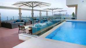 A rooftop pool area with glass railings, lounge seating, and umbrellas. - Centro Corniche Al Khobar (Al Khobar)