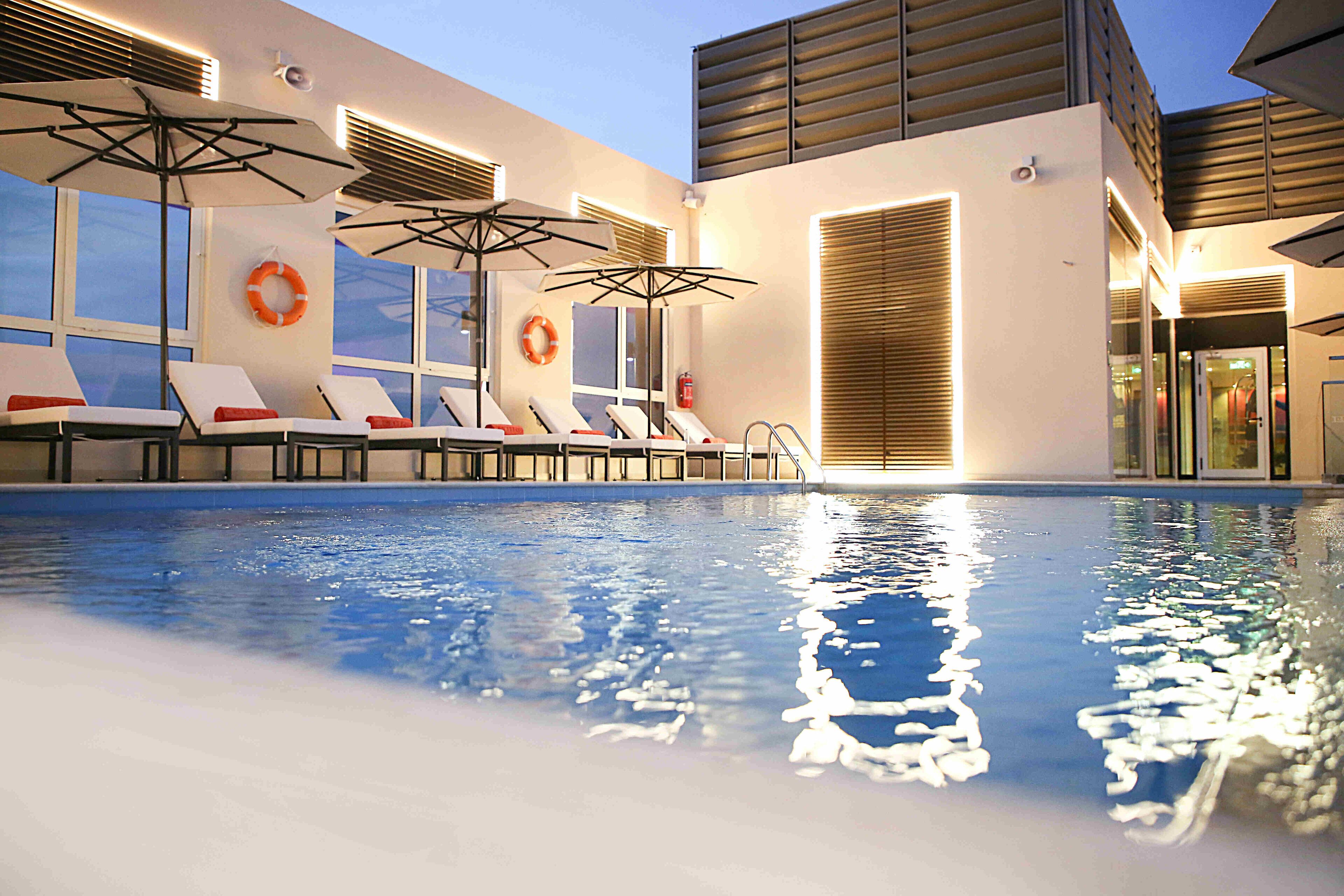 室外游泳池，開放時間為 07:00 至 18:00，提供泳池遮陽傘和日光浴躺椅