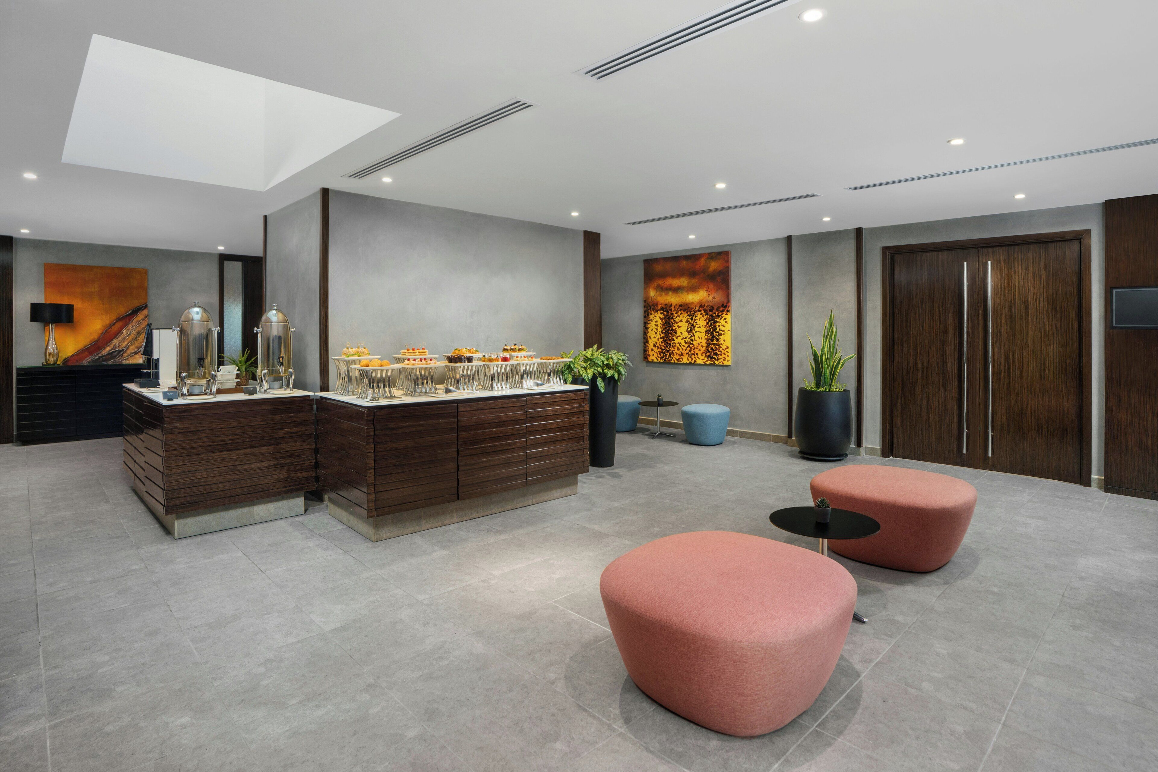 A modern hotel lobby with a central bar area, seating, and artwork on the walls.