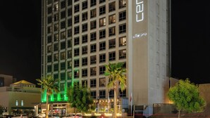 Un hôtel à plusieurs étages, reconnaissable à son grand panneau « CENTRO », qui présente une architecture moderne avec un toit plat et une série de fenêtres.