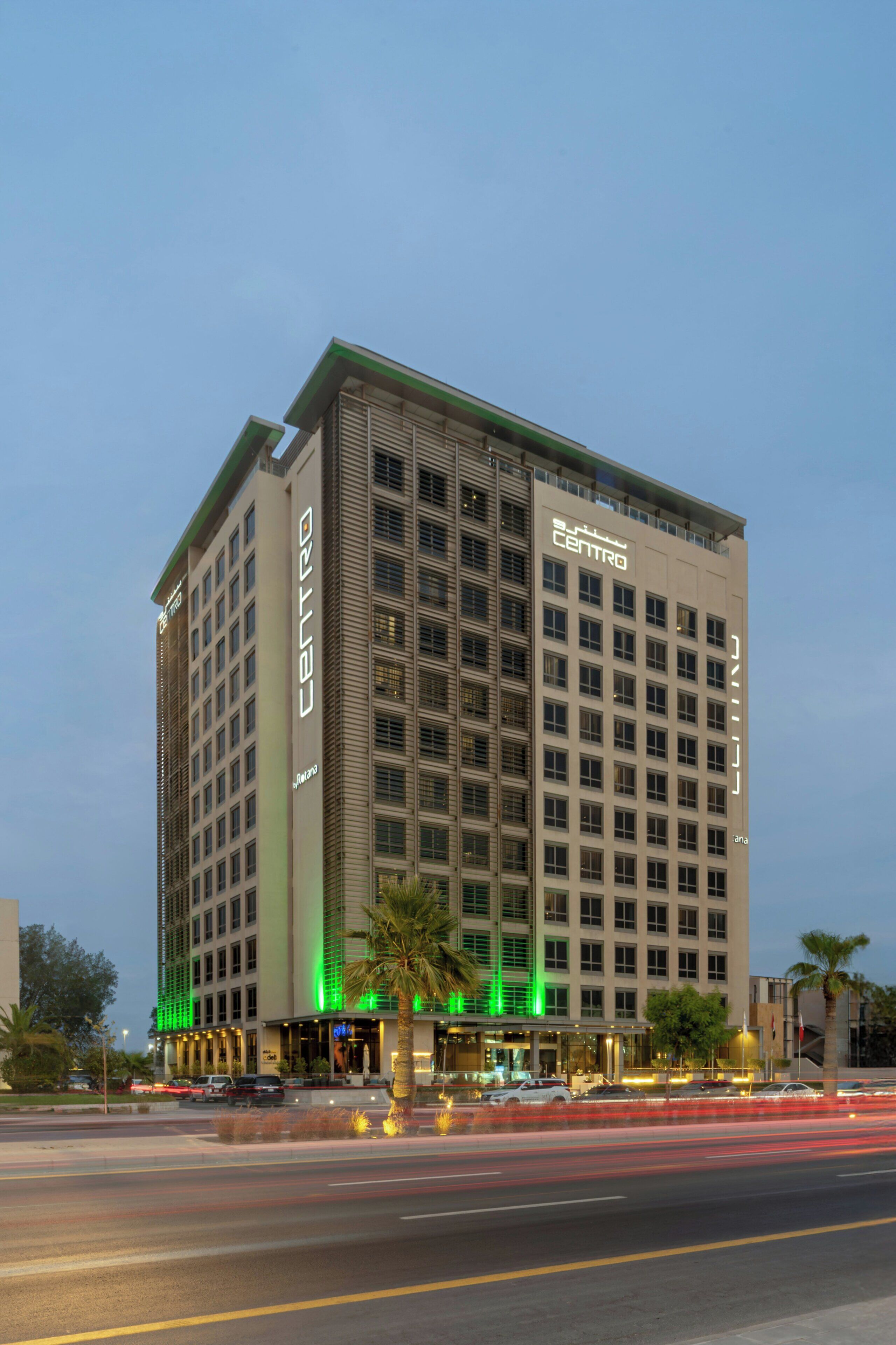 A multi-story hotel with a prominent 'CENTRO' sign, featuring a modern architectural design with a flat roof and extensive window display.