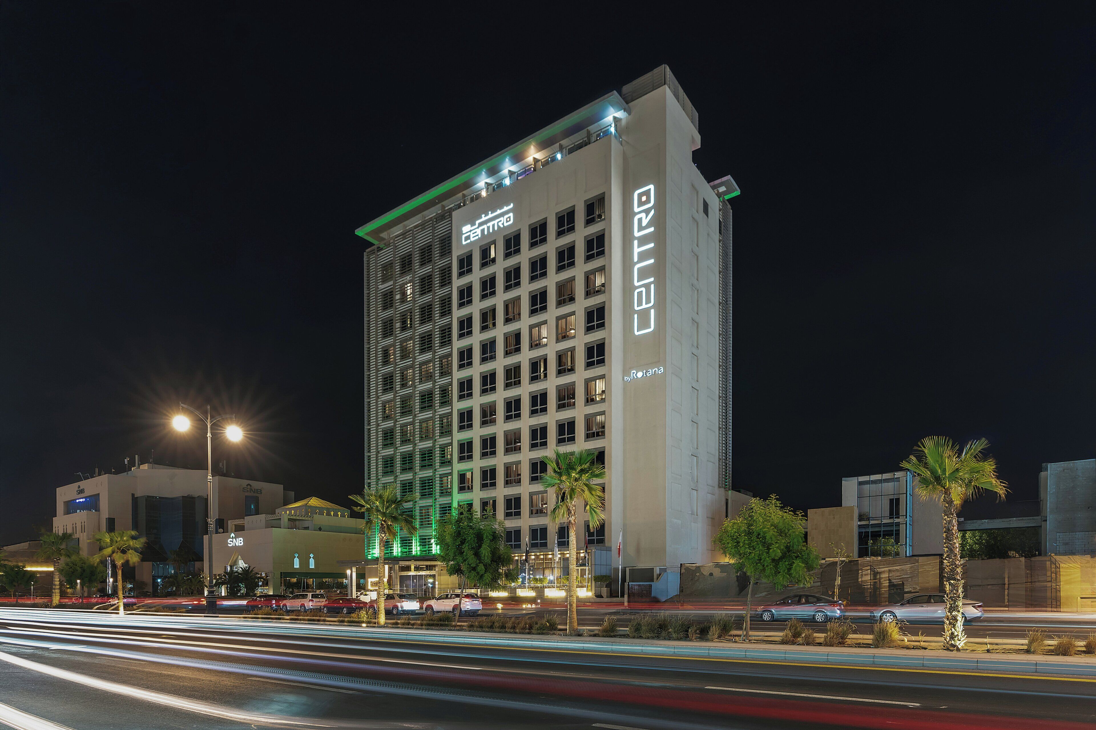 A multi-story hotel with a prominent 'CENTRO' sign, featuring a modern architectural design with a flat roof and extensive use of glass windows.