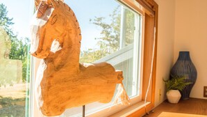A wooden horse sculpture mounted on a window sill, a vase, and a plant on a wooden table. - Historic Creswell Farmhouse Pool+New Spa - 13 min to Eugene, U of O, & Wineries! (Creswell)