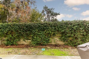 Stroll through the serene garden, surrounded by lush vegetation and a natural wooden fence.