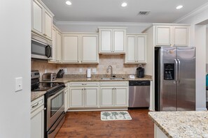 Enjoy cooking in this well-equipped kitchen with a microwave, toaster, oven, sink, and dishwasher.