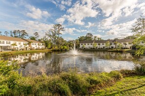 Overlooking a serene lake surrounded by lush greenery and mature trees.