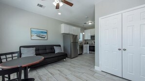 A modern kitchen with white cabinets, a stainless steel refrigerator, and a ceiling fan. - Charming cabin with full kitchen! Unit 1/6 (San Leon)