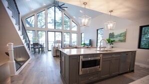 Una cocina moderna con una isla grande, electrodomésticos de acero inoxidable y un comedor con vistas.