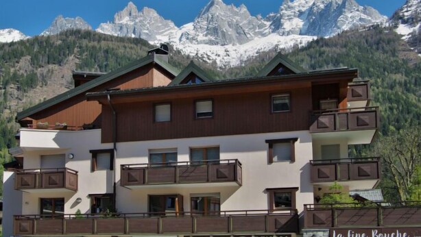 A multi-story building with balconies, a restaurant named "La Fine Bouche," and a sign for "Interhome" and "L'LOCATION RENTAL." - L'Espace Montagne by Interhome (Chamonix)