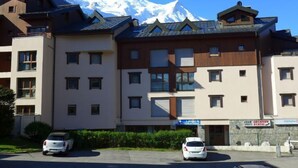 A multi-story hotel with a mountain backdrop. - L'Espace Montagne by Interhome (Chamonix)