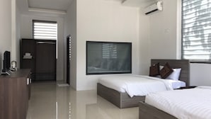 Ein modernes Schlafzimmer mit zwei Betten, einem Schreibtisch und einem Kleiderschrank.