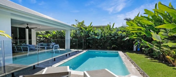 Relax by the pool surrounded by lush tropical plants and comfortable lounge seating.