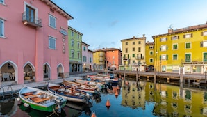 A row of colorful buildings along a canal with boats docked in front.