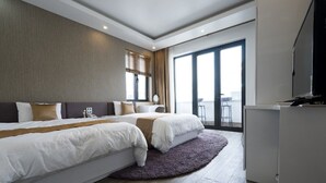 A modern hotel room with two beds, a large window, a balcony, and a flat-screen TV. - BBQ Hostel Ha Long (Ha Long)
