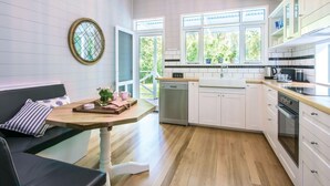 Una cocina moderna con armarios blancos, encimera de madera y lavavajillas integrado.