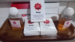 A tray with hotel toiletries including shampoo and soap, with contact information for Hotel Rauda. - Rauda Hotel Syariah (Pekanbaru)