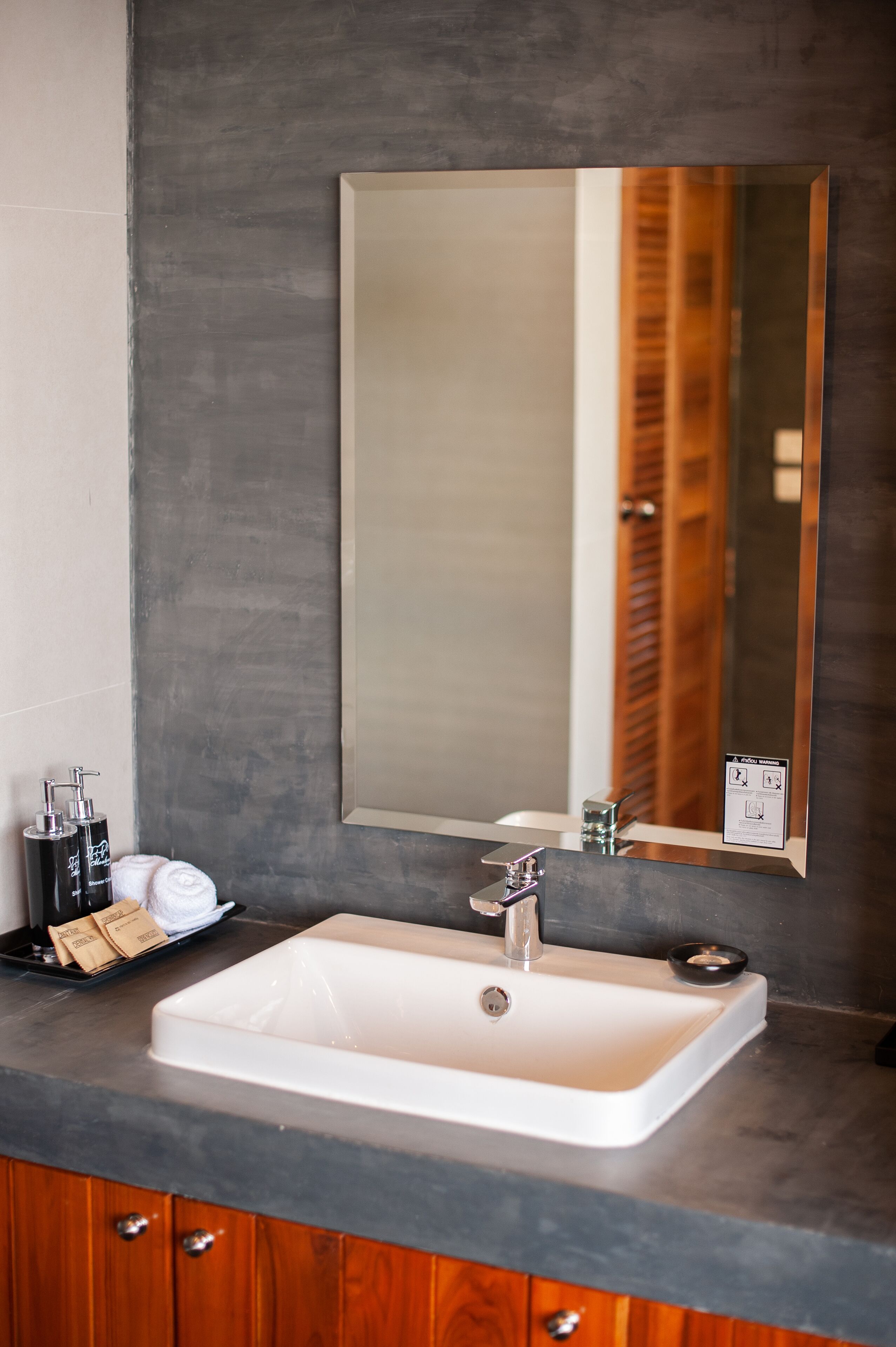 A bathroom with a white sink, a mirror, and a wooden cabinet.