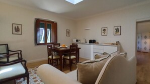 A compact living space with a dining area, kitchenette, and a sofa. - Olive Tree Suite Apartment (Piombino (LI))