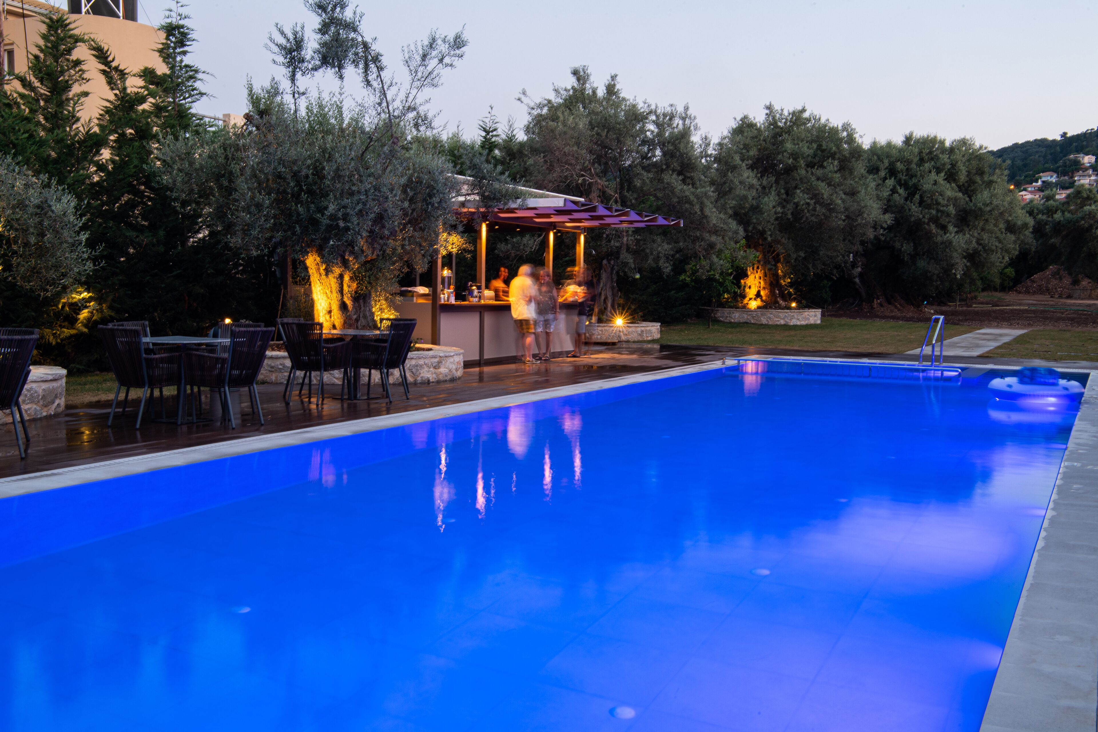 A swimming pool with a bar area and outdoor seating.