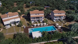 Um imóvel residencial com piscina, várias varandas e um jardim bem cuidado.