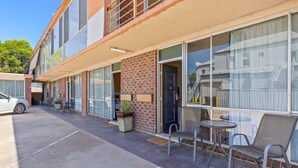 A building with a brick facade, large windows, and outdoor seating.