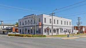 A two-story building with a sign for the Albion Hotel, a drive-thru, and a keep left sign.