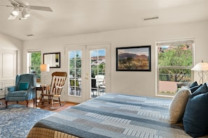 Relax in this serene room with a large bed, seating area, and stunning mountain views.