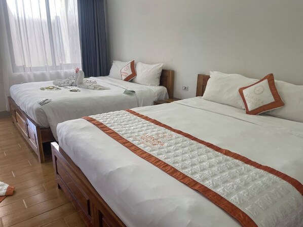 A hotel room with two beds, each with white bedding and a brown accent. - Aurora House (Phu Quoc)