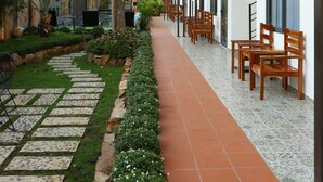 A covered outdoor area with a pathway, seating, and greenery. - Aurora House (Phu Quoc)