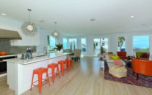 A spacious kitchen with a central island, bright lighting, and a view of the outdoors. - On the Beach: Breathtaking 180 degree views of Gulf of Mexico (Holmes Beach)