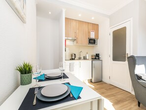 A compact kitchen with a microwave, sink, and refrigerator.