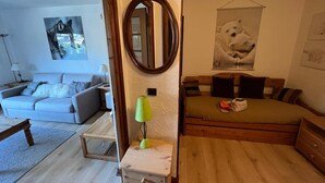 Un dormitorio con una cama, una mesita de noche, un espejo y una pared decorada con un cuadro de un oso.