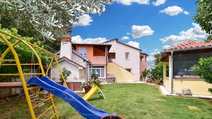 A residential area with a playground featuring a slide, a yellow swing set, and a green climbing frame. - Apartment 1985/27393 (Istria - Pula), 1000m from the beach (Pula)