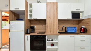 A compact kitchen with white cabinets, a built-in oven, a coffee maker, and a kettle. - Apartment 1985/27393 (Istria - Pula), 1000m from the beach (Pula)