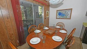 A dining area with a wooden table, chairs, and a map on the wall.
