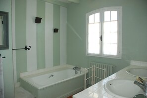 A bathroom with a bathtub, two sinks, a window, and a radiator. - Provence ideally located in the middle of vineyards, single storey villa 8 pers. (Gigondas)
