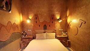 A room with a bed, two nightstands, a wall mural, and two wall-mounted lights. - Dar Tafouyte (Taouz)