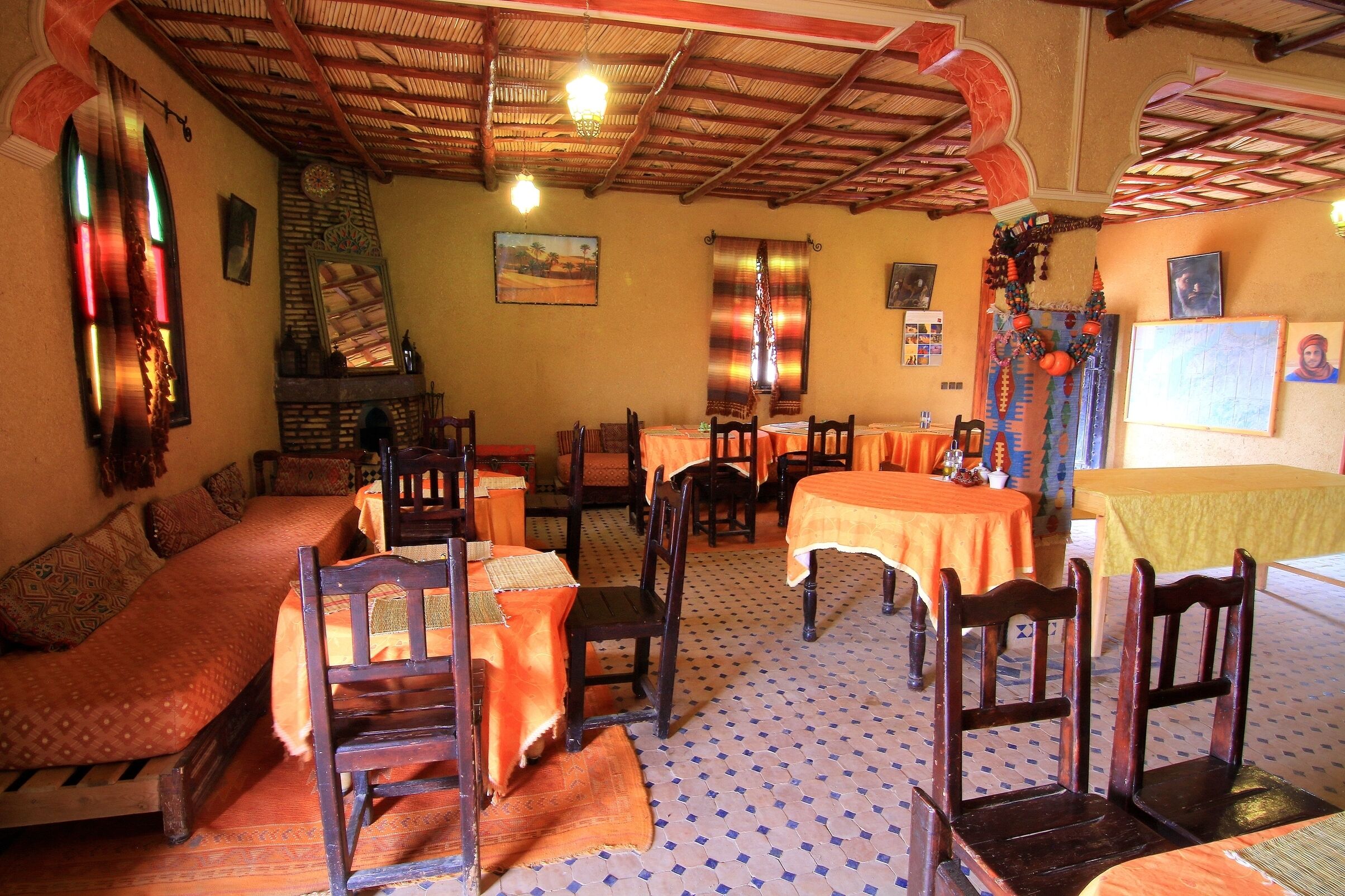 Un'antica locanda con arredi in legno, piastrelle a motivi decorativi e un soffitto rustico.