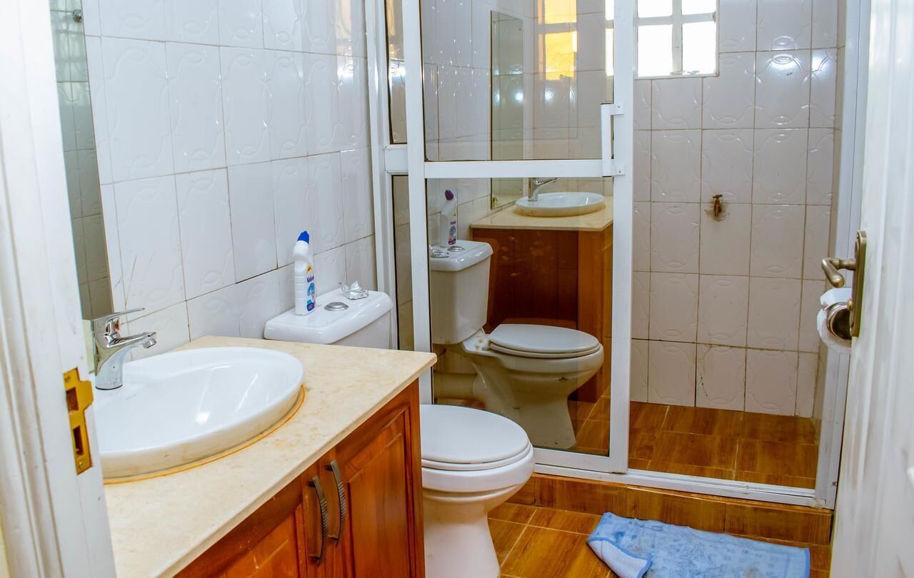 Een badkamer met een wastafel, toilet en douchehoek.