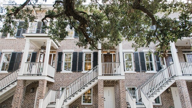 A multi-story brick building with white railings and a central door. - Plunge Pool and Parking, 3 Stories in Historic Downtown by Lucky Savannah (Savannah)
