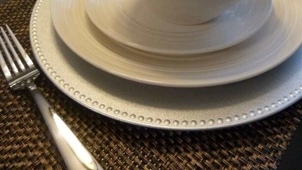 A dining table set with a white bowl, a plate, a fork, and a glass. - Quiet Townhome in central Raleigh (Raleigh)
