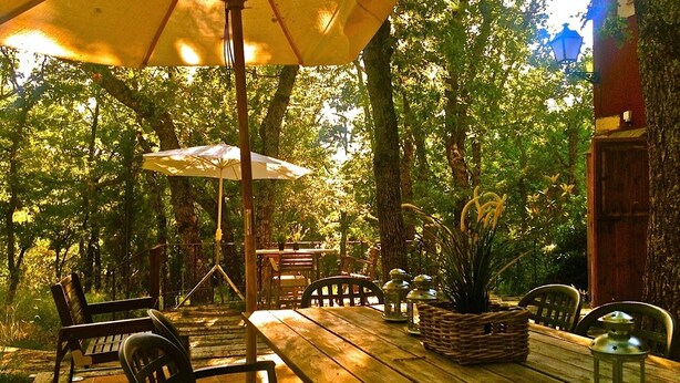 An outdoor wooden table with chairs, a wicker basket, and a lantern. - A magical house in the heart of Guadarrama Park (Collado Hermoso)