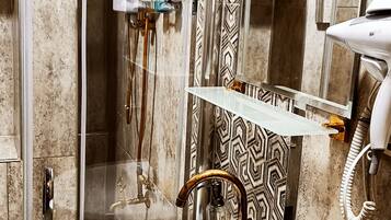 Un baño con lavamanos blanco, ducha y pared con diseño.